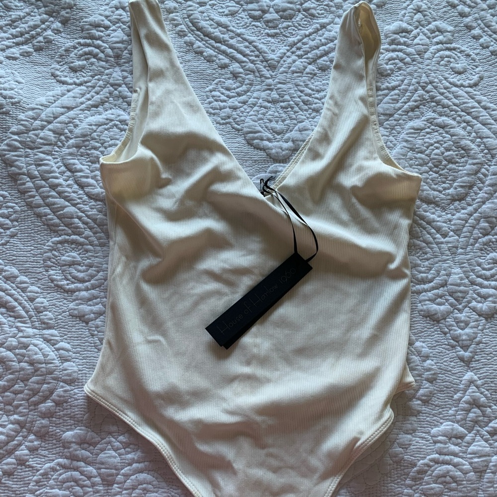 Frame plunging V neck bodysuit in cream color.